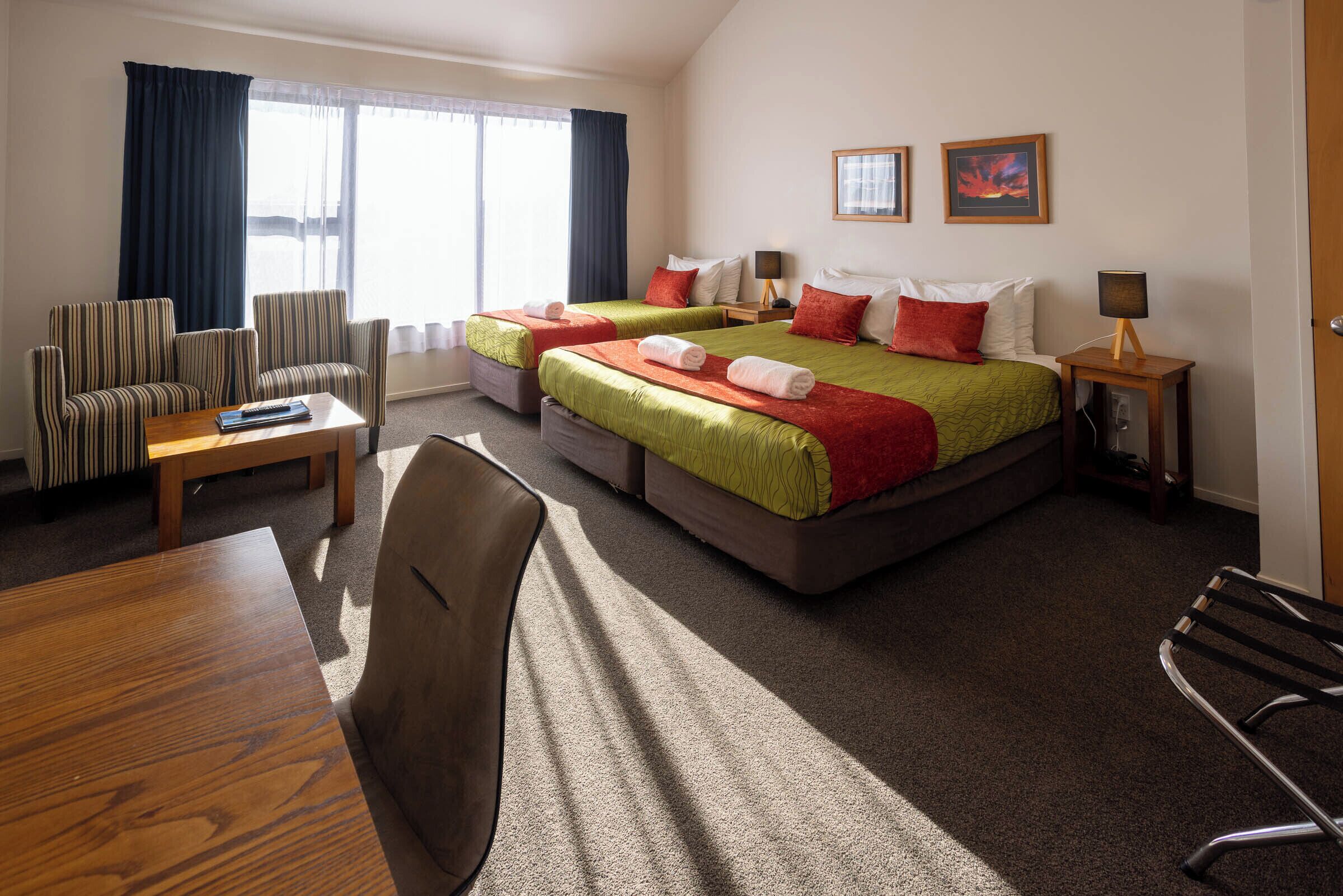 Una habitación de hotel con dos camas, un escritorio, una silla y un sofá.