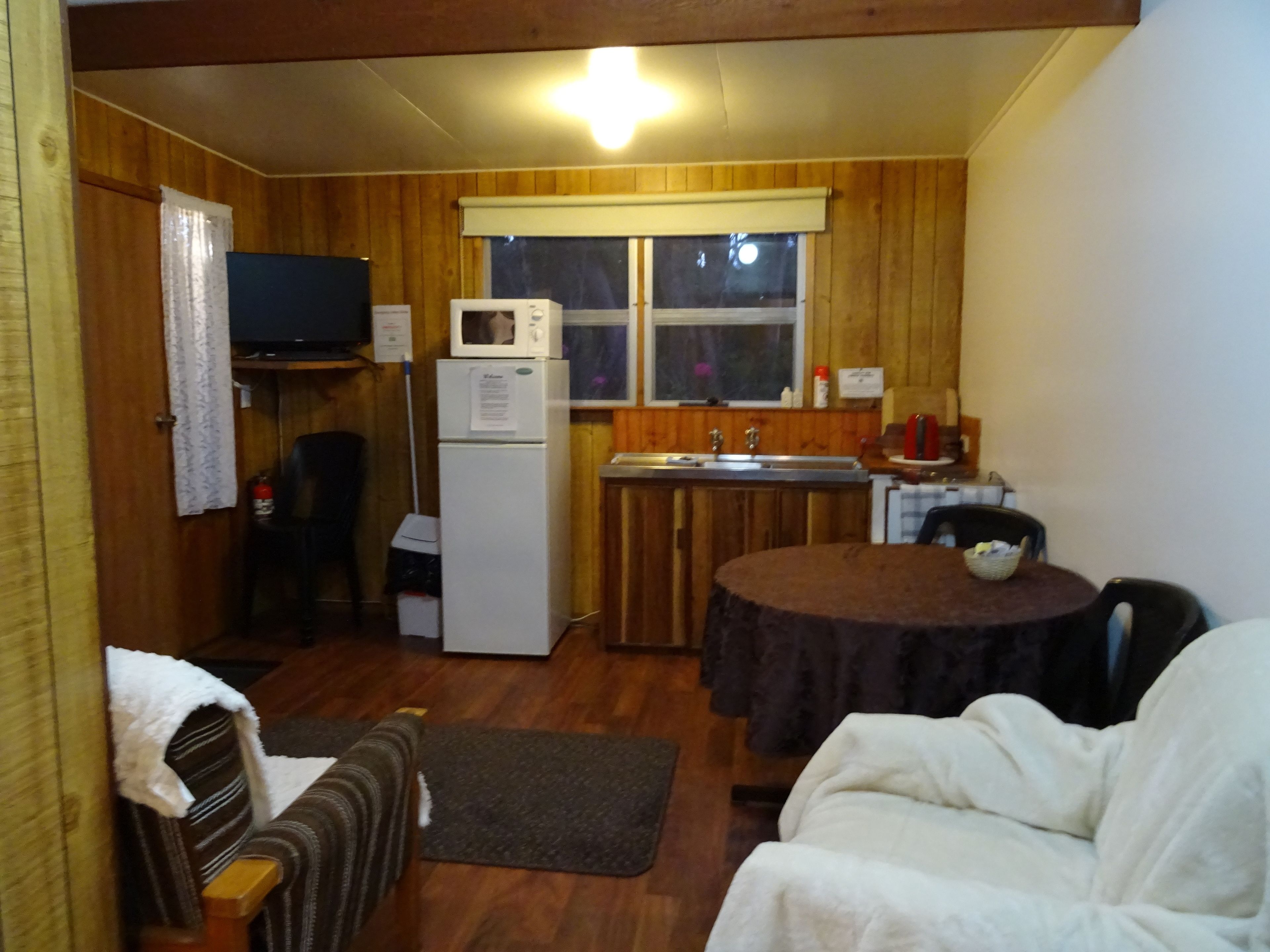 A compact living space with a kitchenette, a dining area, and a sofa.