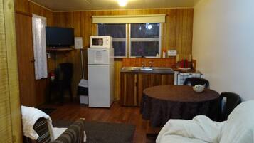 A compact living space with a kitchenette, a dining area, and a sofa.