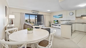 A modern apartment with a dining area, kitchen, and living space. - Rovera Apartments (Maroochydore)