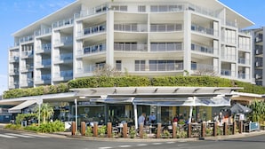 A multi-story hotel with balconies, outdoor seating, and a coffee shop. - Rovera Apartments (Maroochydore)