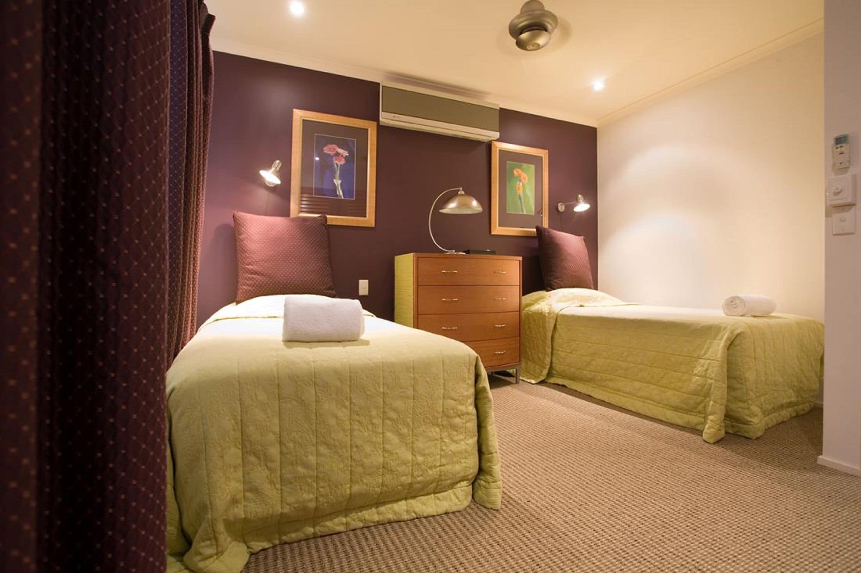 Una habitación de hotel con dos camas, un aparador y un ventilador de techo.