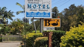 A motel sign with amenities including free movies, air conditioning, BBQ, boat/trailer/truck/bus parking. - Black Swan Waterfront Motel (Swansea)