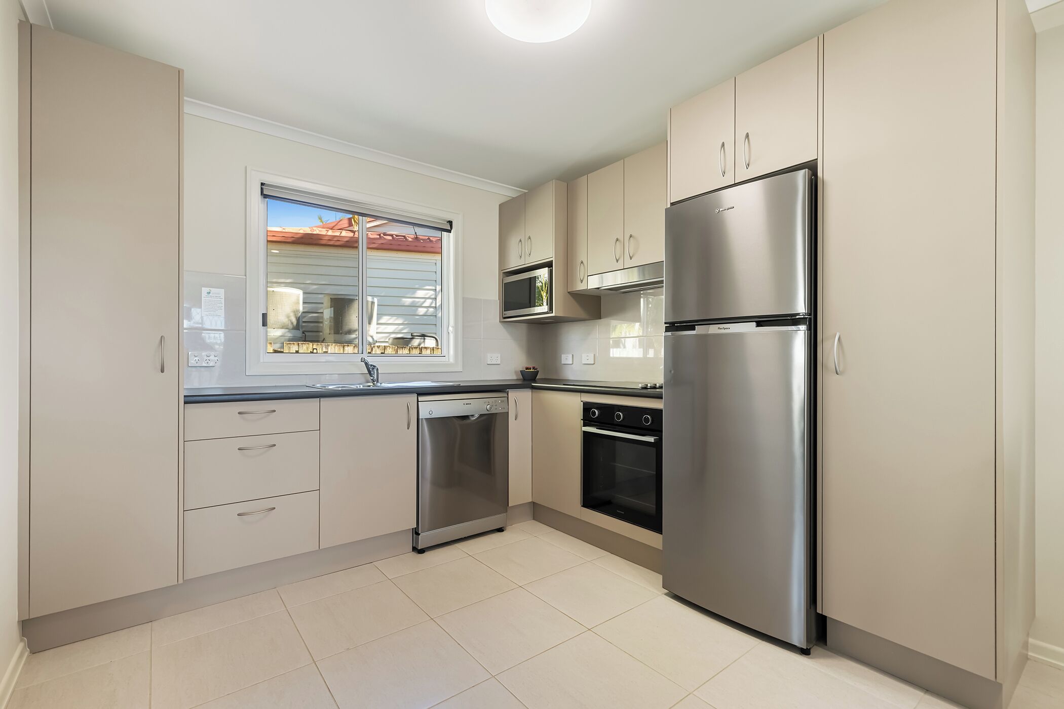 A kitchen with a dishwasher, oven, microwave, and refrigerator.