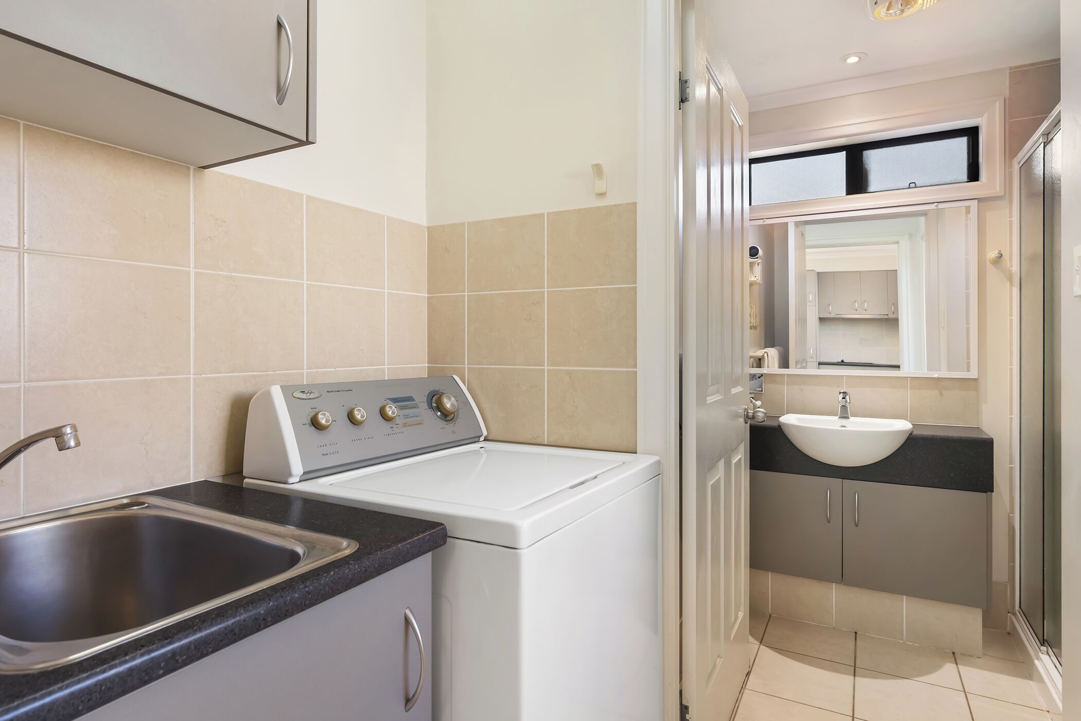 A compact kitchen with a washing machine, a sink, and a countertop.