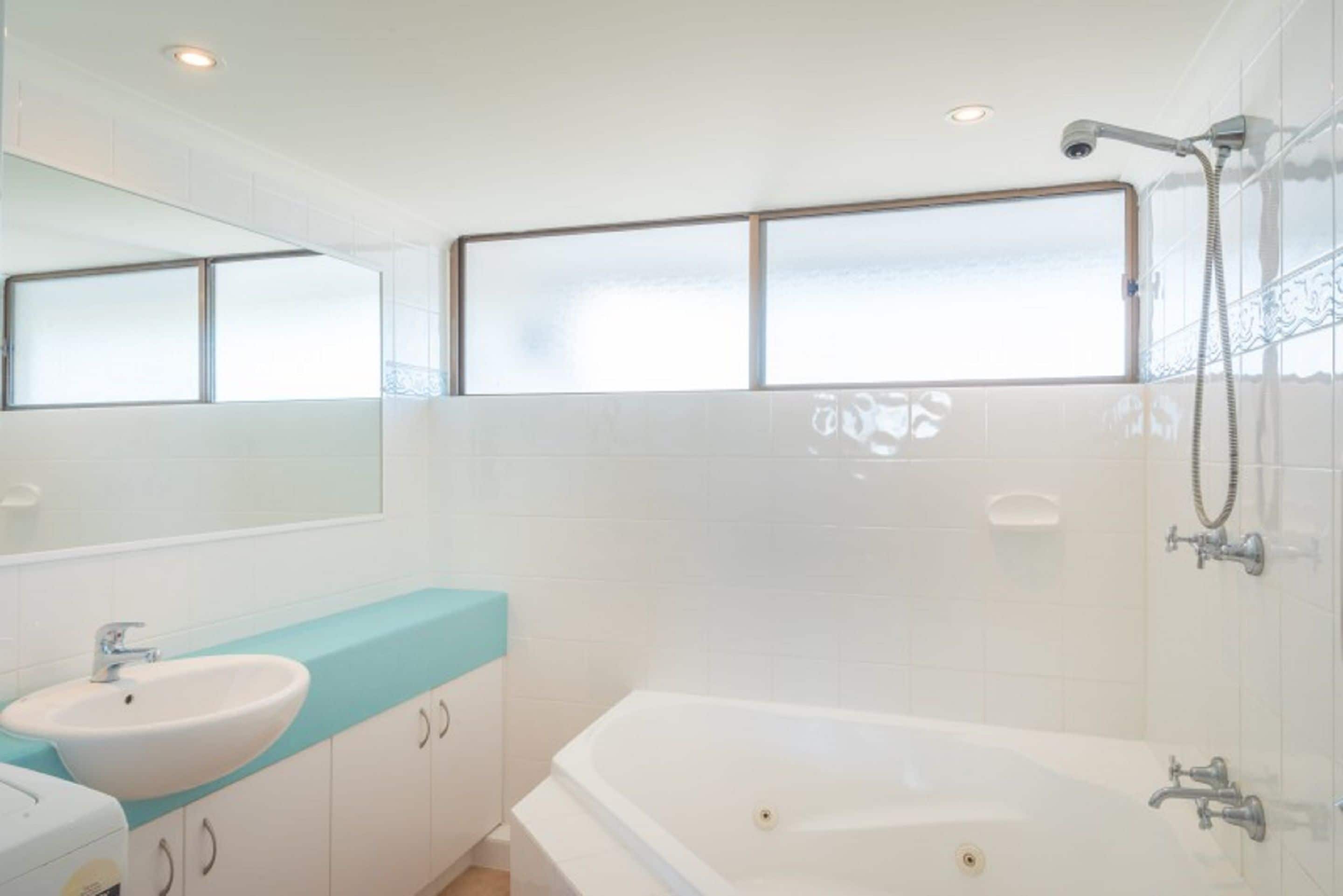 A modern bathroom with a bathtub, a sink, and a shower.