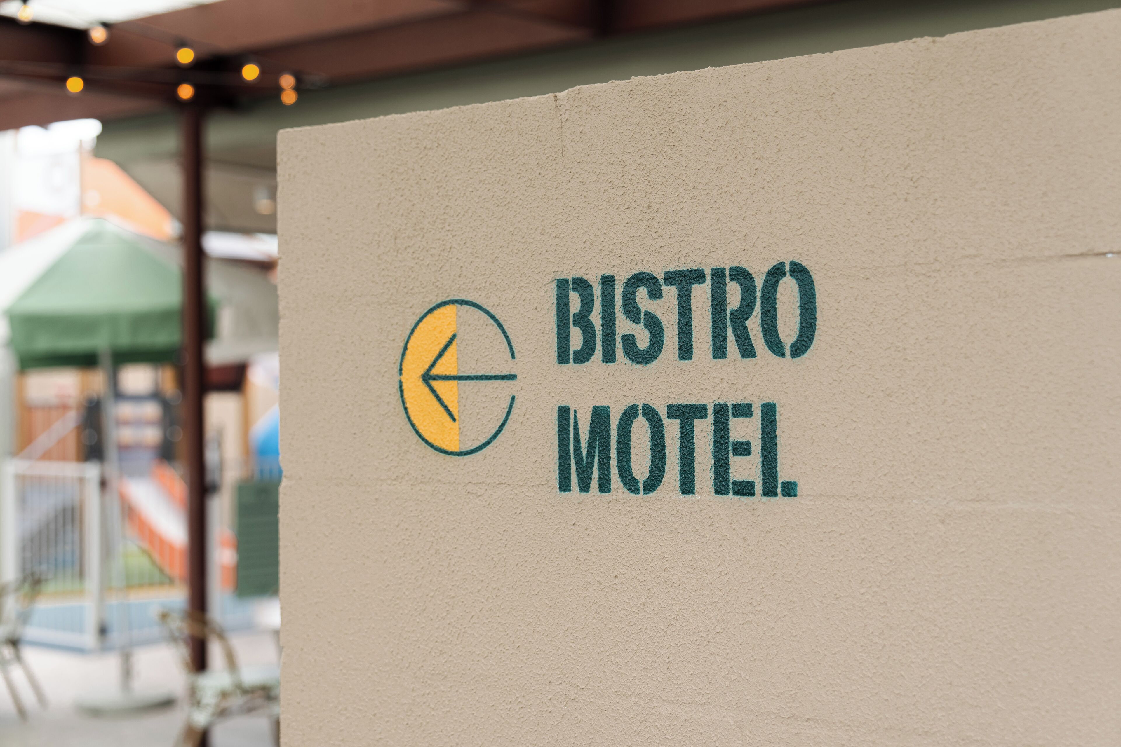 Señal para Bistro Motel, con una flecha direccional y un logotipo.