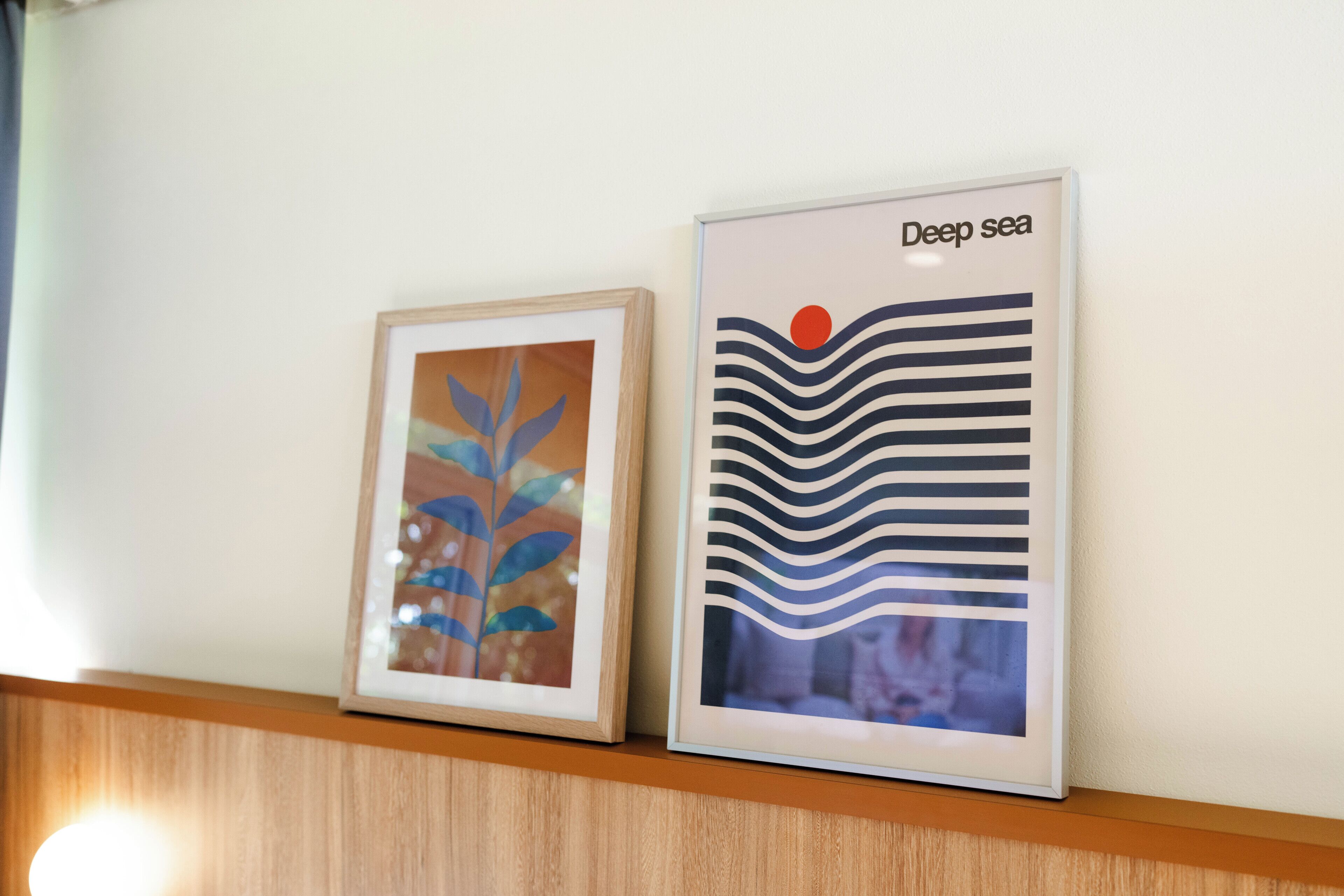 Deux œuvres d’art encadrées sont accrochées au mur.