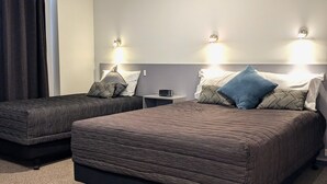 A hotel room with two beds, a large window with curtains, and wall-mounted lights. - The Peninsula Kaikoura (Kaikoura)
