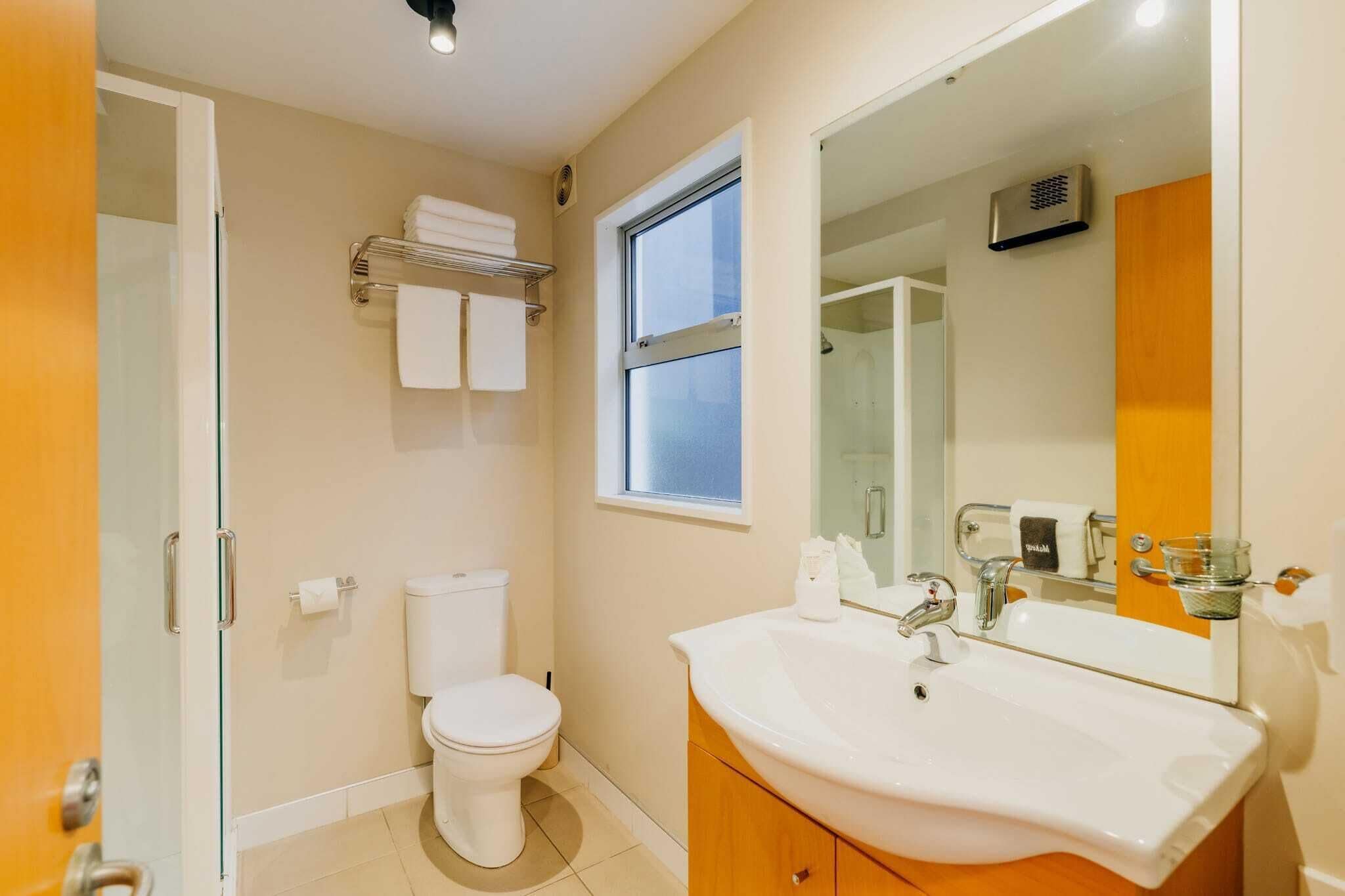 Un baño con inodoro, lavamanos y ventana.