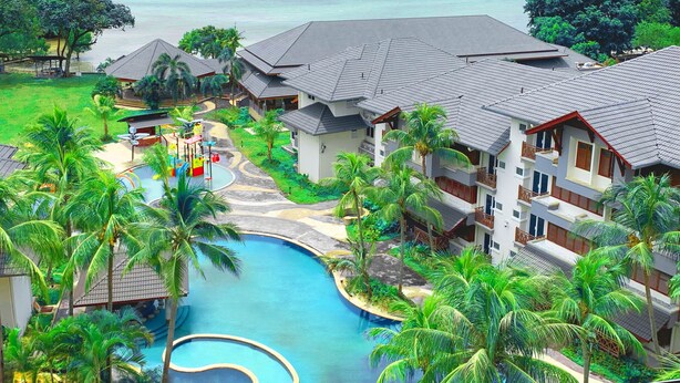 Um resort com piscina, vários edifícios e vista para o mar.