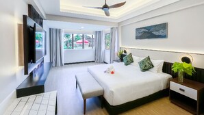Quarto de hotel moderno com uma cama grande, televisão de tela plana, ventilador de teto e vista para o exterior.