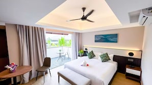 Quarto de hotel com cama, mesa de cabeceira, cadeira e uma pequena varanda com mesa e cadeira.