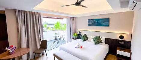 A hotel room with a bed, bedside table, chair, and a small balcony with a table and chair.
