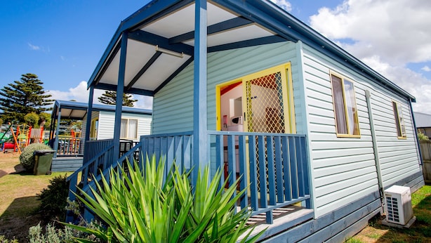 A mobile home with a porch, a fenced yard, and a playground in the background. - BIG4 Port Fairy (Port Fairy)