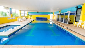 An indoor swimming pool with clear lane markings, a 'NO RUNNING' sign, and a seating area with chairs. - BIG4 Port Fairy (Port Fairy)