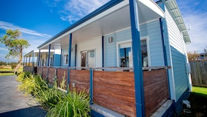 A single-story house with a covered porch, a front door, and a small front yard with grass and plants. - BIG4 Port Fairy (Port Fairy)