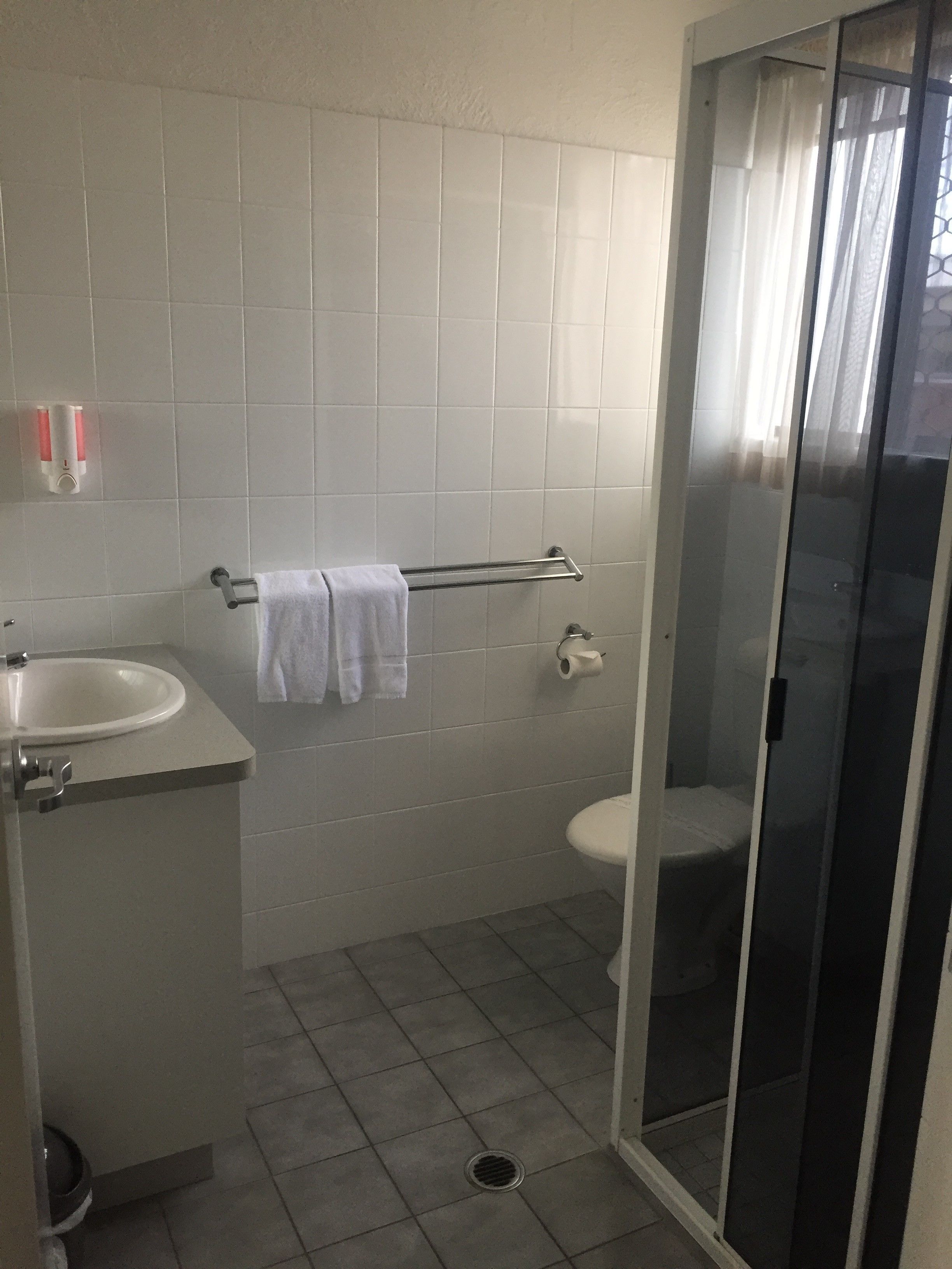 A bathroom with a sink, toilet, and shower.
