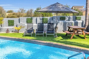 Outdoor pool, a heated pool, pool umbrellas, pool loungers