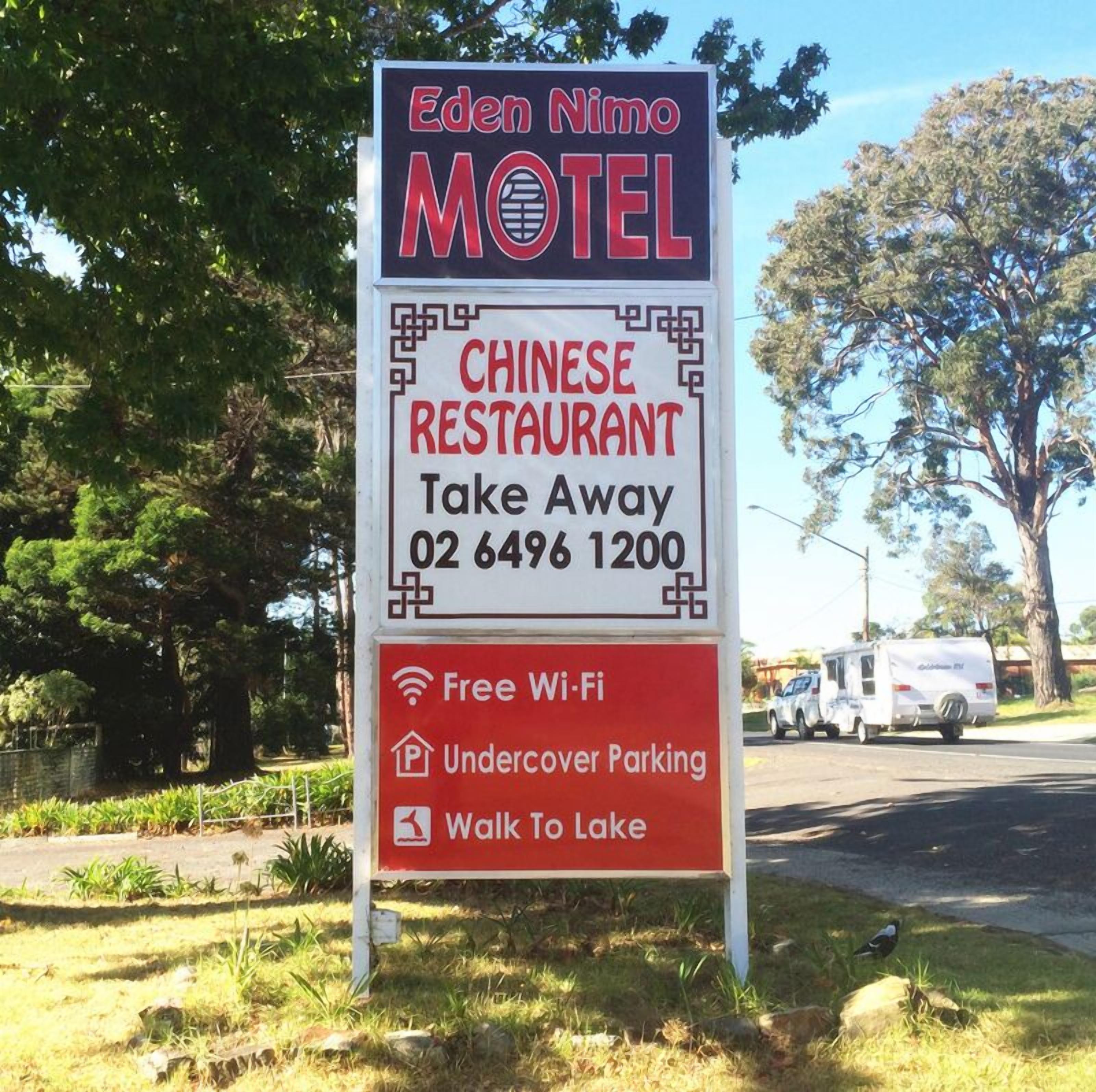 A sign for Eden Nimo Motel advertising a Chinese restaurant, free Wi-Fi, undercover parking, and a walk to the lake.