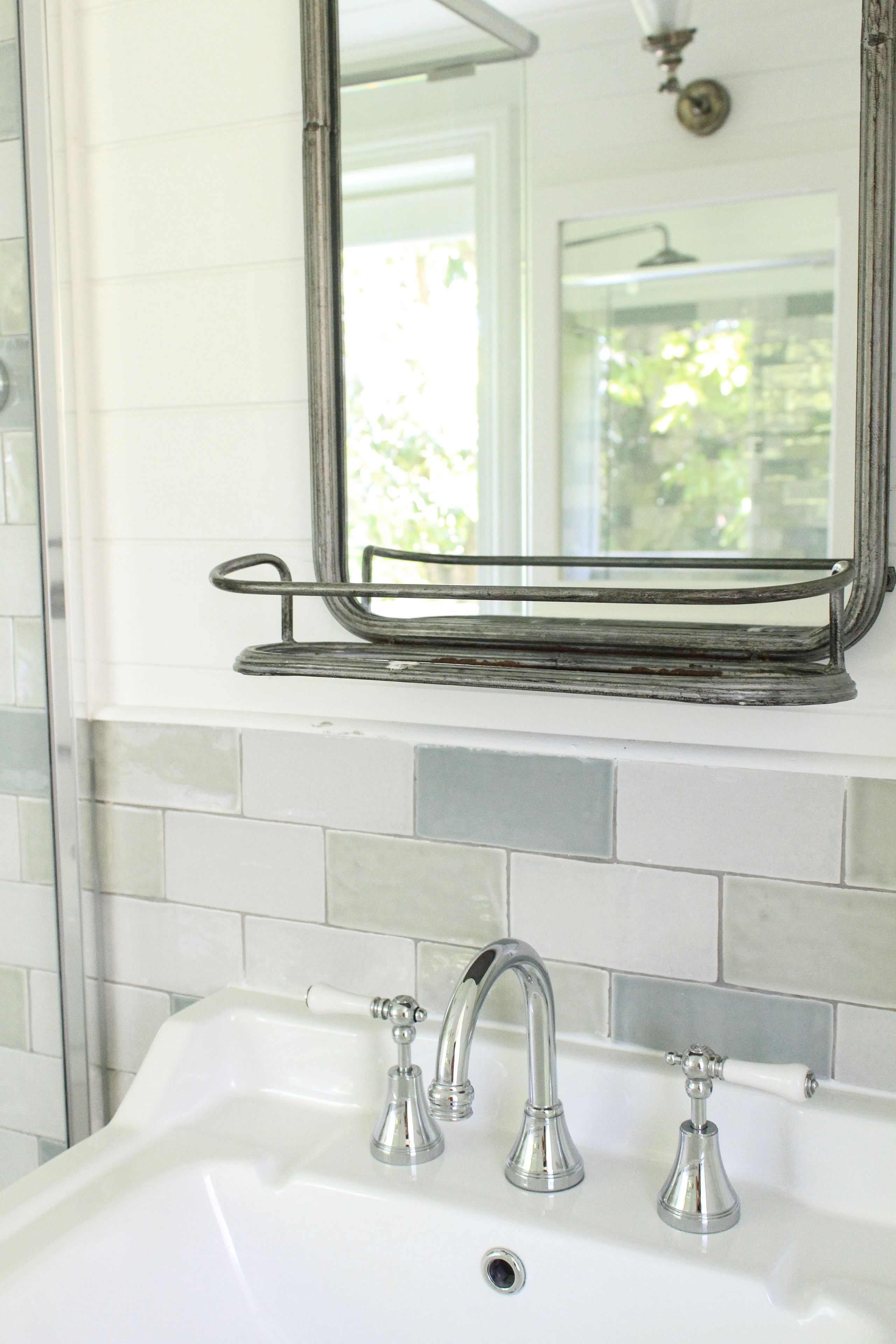A bathroom with a white sink, three faucets, and a mirror above it.