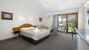 Une chambre comprenant un lit, un canapé, une table à manger et un coin cuisine.