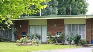 A two-story motel with a brick facade, large windows, and a covered porch.