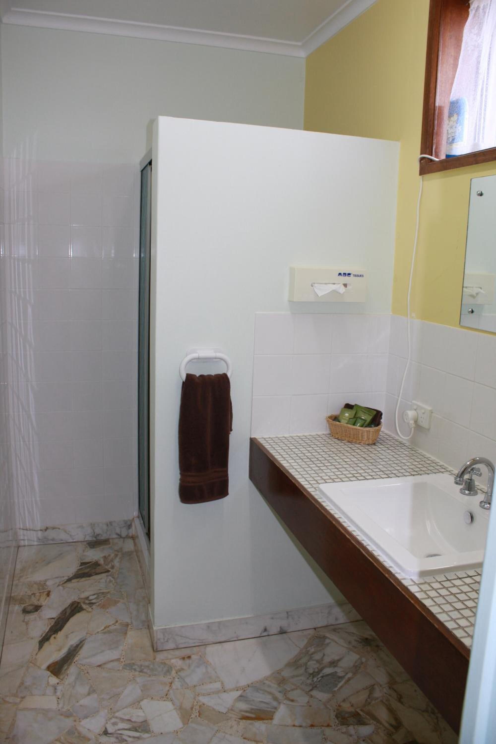Un baño con ducha, lavabo y espejo.