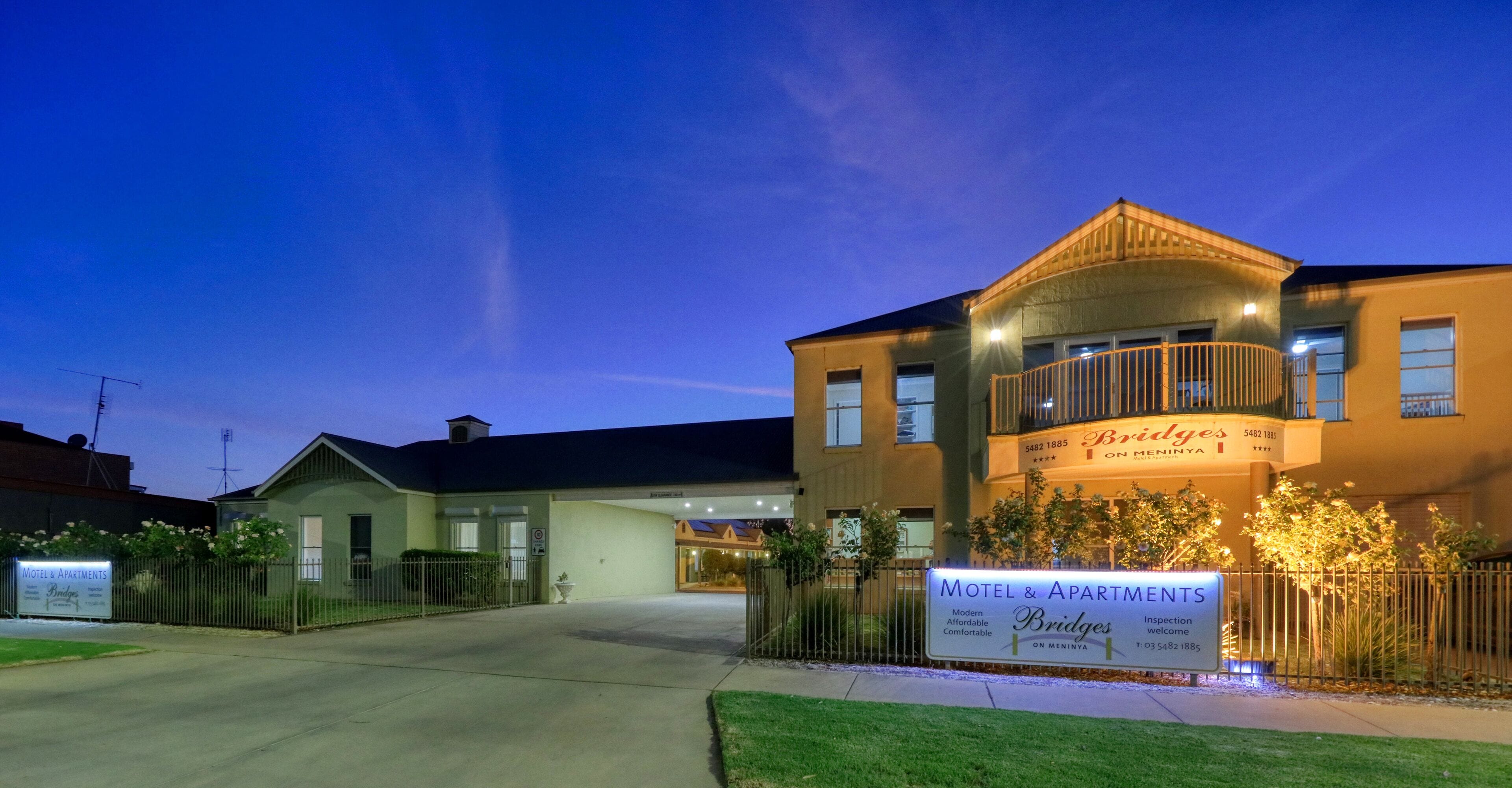 A motel and apartment complex with a sign indicating it is on Meninaya.