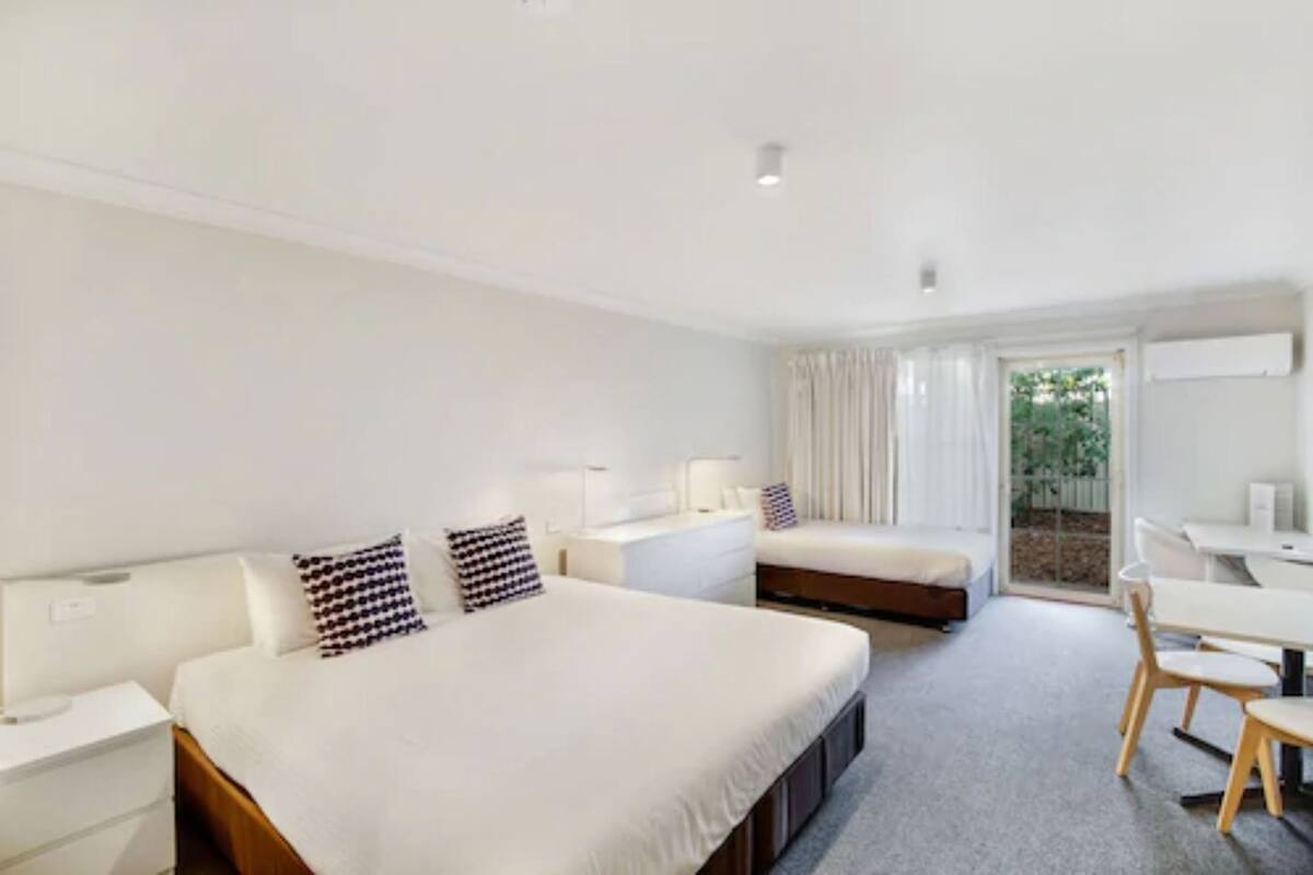 Ein modernes Hotelzimmer mit einem großen Bett, einem Schreibtisch und einem Sessel.