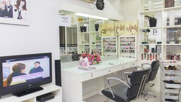 L'intérieur d'un salon avec un téléviseur, des étagères blanches et un miroir.