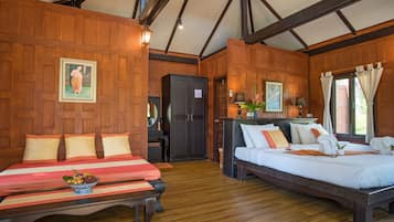 A room with two beds, wooden walls, a wooden ceiling, and a small table with fruit.