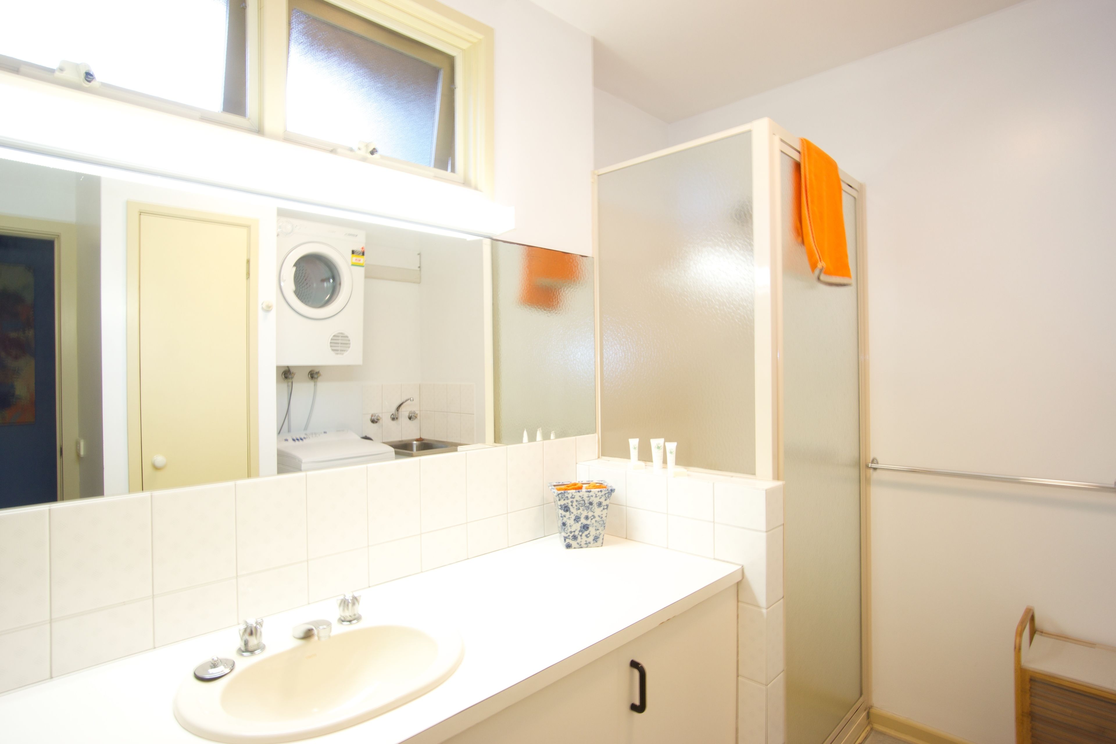 Un baño con lavabo, espejo, toallero y cabina de ducha.