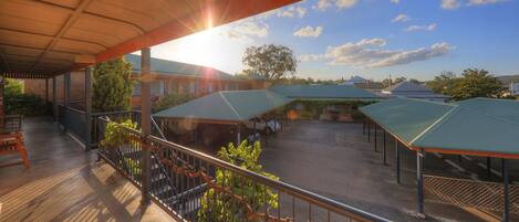 A covered outdoor area with multiple buildings, a paved ground, and a clear sky.