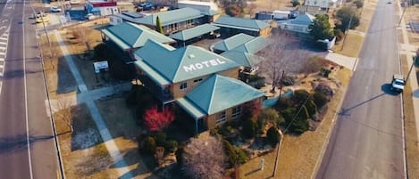 Et motel med et grønt tag, beliggende i et vejkryds.