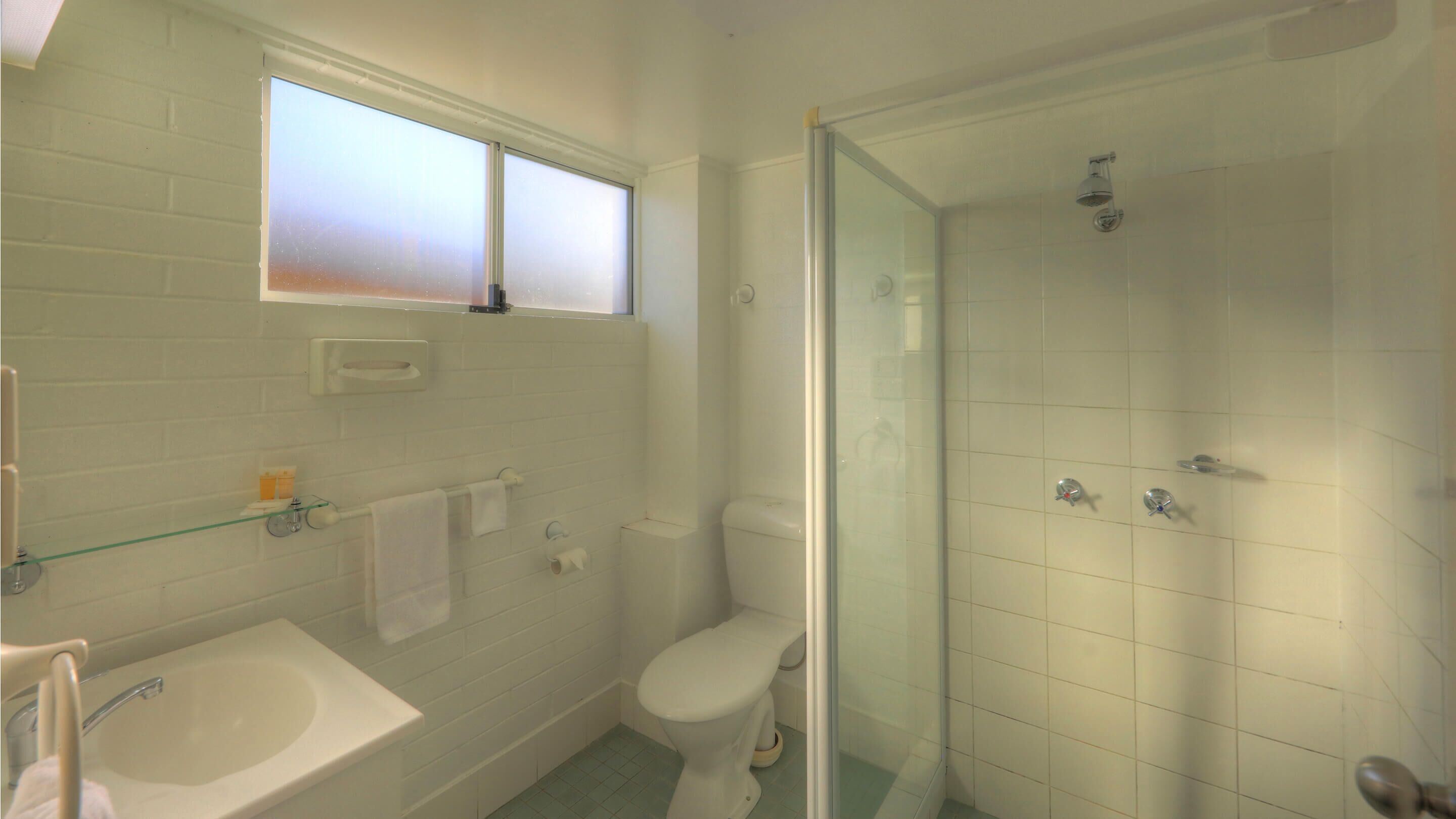 Een badkamer met een bad, toilet en een douchecabine.