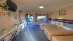 A hotel room with a dining area, two single beds, a desk, and a TV. - The Vines Motel and Cottages (Stanthorpe)