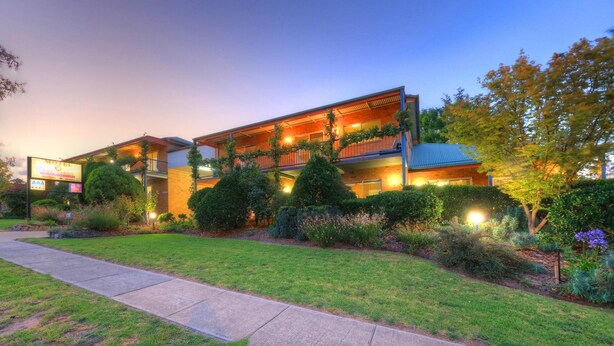 A motel with a two-story structure, a covered outdoor area, and well-maintained landscaping. - The Vines Motel and Cottages (Stanthorpe)