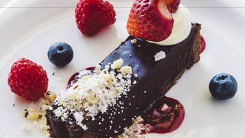 A dessert with chocolate, strawberries, and raspberries on a white plate.