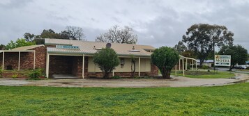 Un edificio de ladrillo de dos plantas con un letrero que dice 'Belvoir Village Motel'.