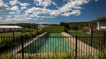 Una piscina al aire libre, sillones reclinables de piscina