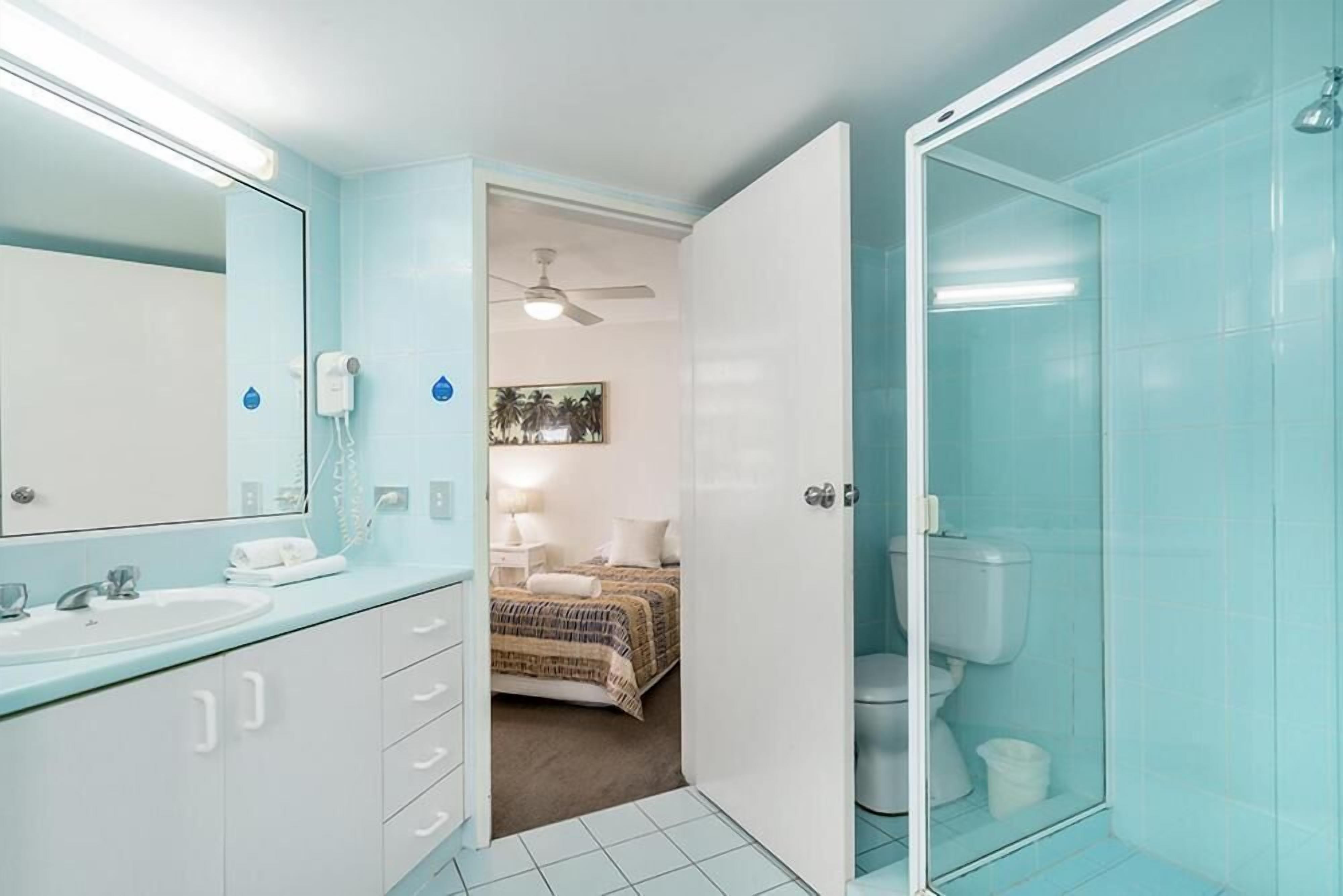 Une salle de bain avec douche, toilettes et lavabo.