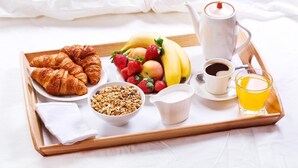 A breakfast tray with croissants, fruits, granola, coffee, milk, and juice. - AAA Northlands Motel (Christchurch)