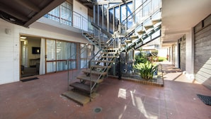 A spacious atrium with a central staircase, large windows, and a small garden area. - Epsom Motel (Auckland)