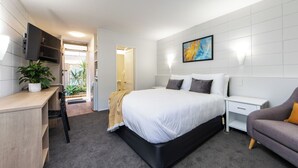 A modern bedroom with a large bed, a desk, a chair, and a sofa. - Epsom Motel (Auckland)