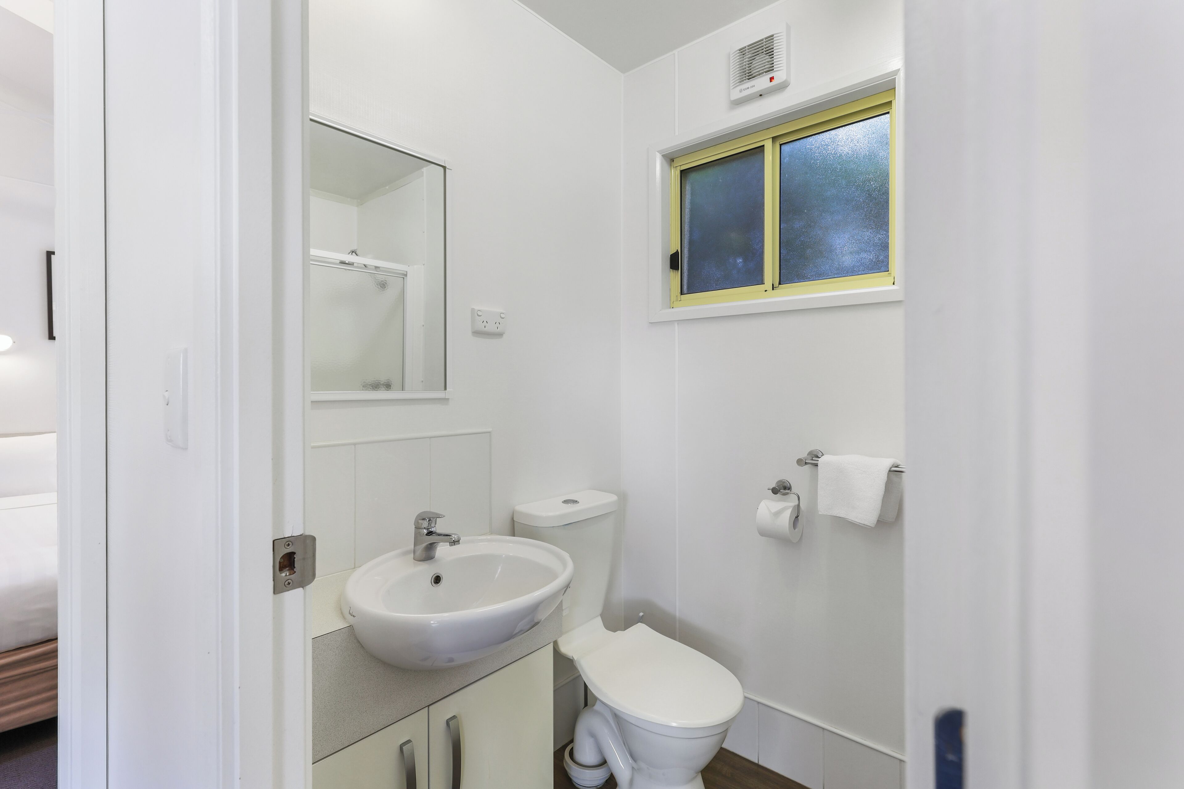 Ein Badezimmer mit Waschbecken, Toilette und Spiegel.