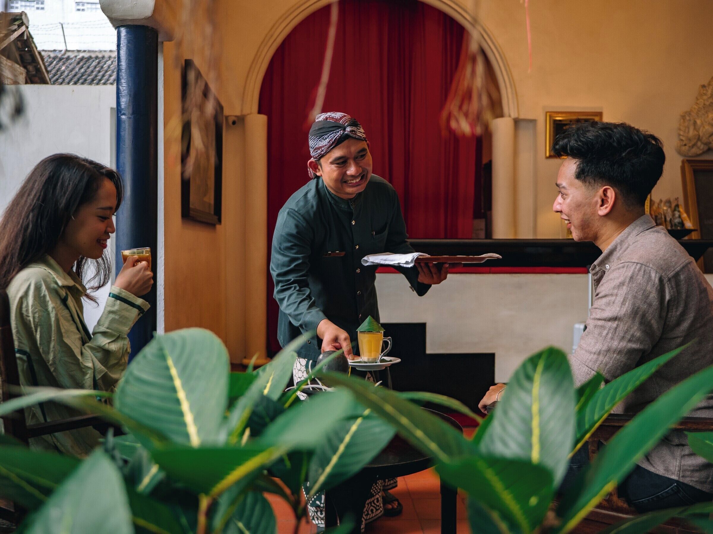 Un restaurante con un camarero sirviendo comida a los comensales.