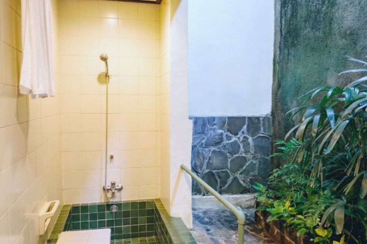 A bathroom with a shower, a toilet, and a sink.