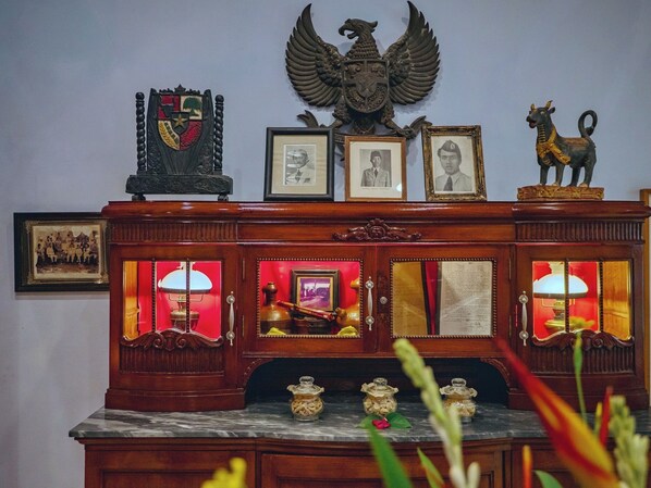 A wooden cabinet with glass doors, framed photographs, and decorative items.
