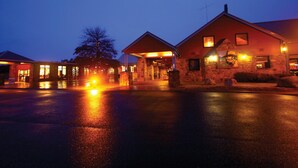 A building with a stone facade and a covered entrance area, likely a hotel or similar establishment. - The Station (Jindabyne)